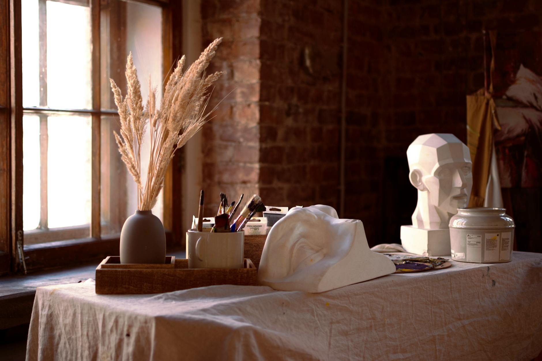 Établi d’atelier garni d’outils, de pinceaux et de plantes séchées